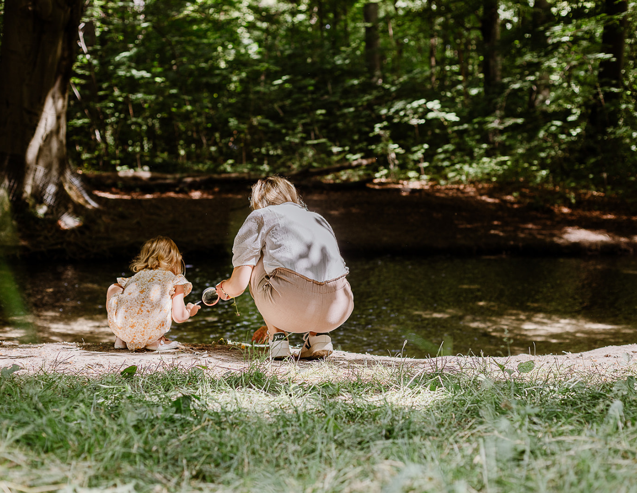 Mutter und Kind forschen in der Natur