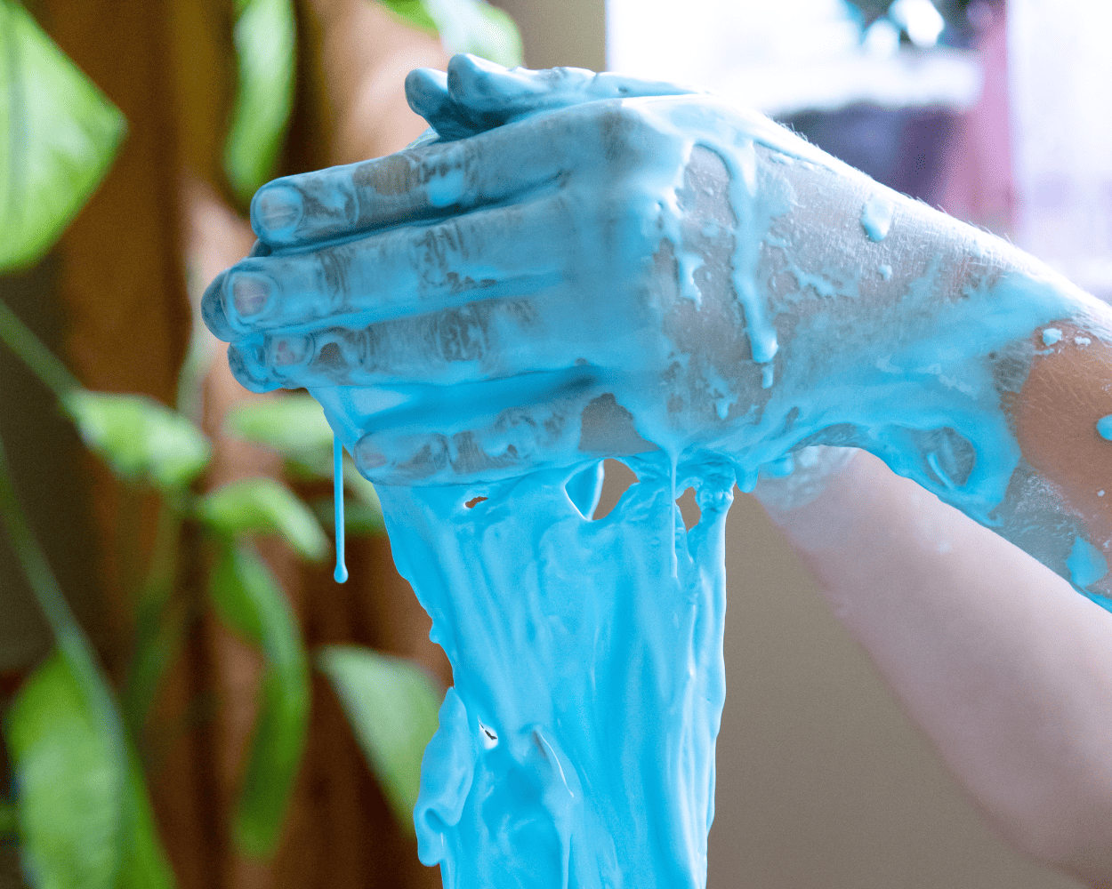 Kinderhände mit blauem Matsch
